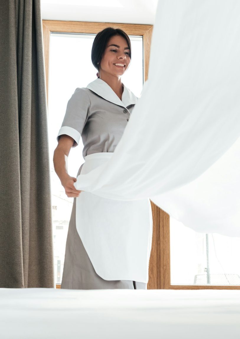 Hotel maid changing bed sheet
